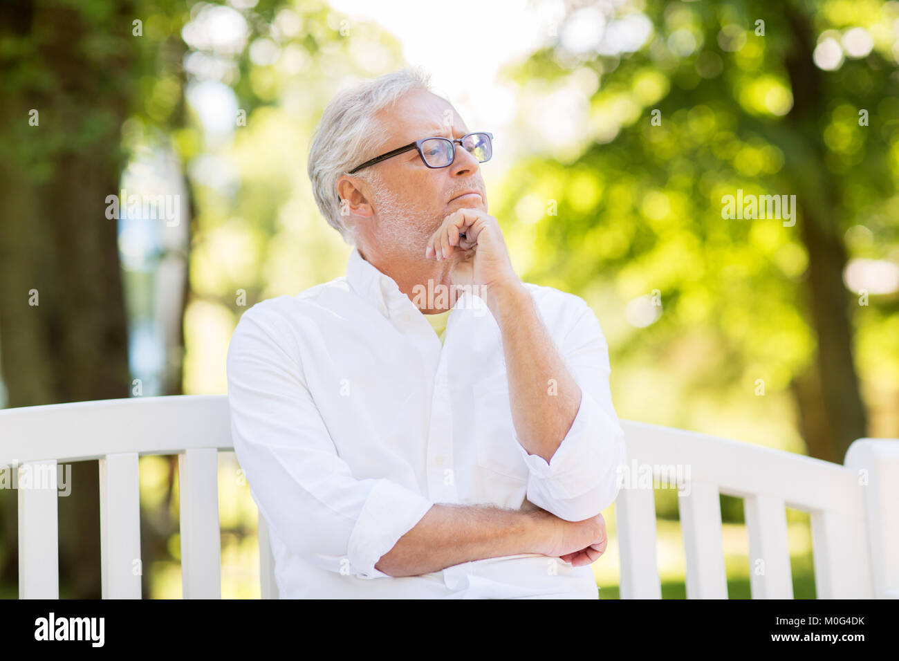 Nachdenklich älterer Mann an Sommer Park Stockfoto