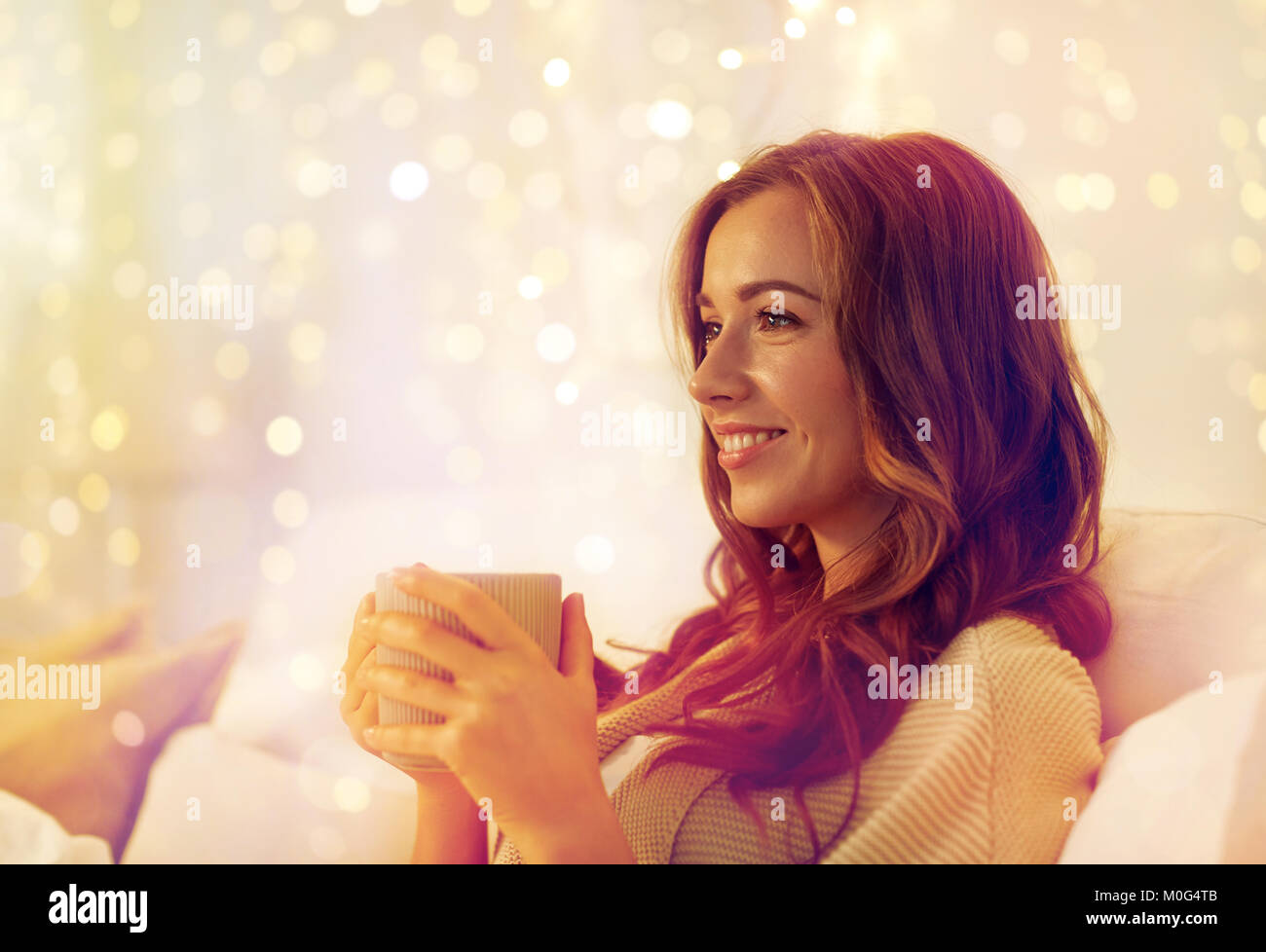 glückliche Frau mit Tasse Kaffee im Bett zu Hause Stockfoto