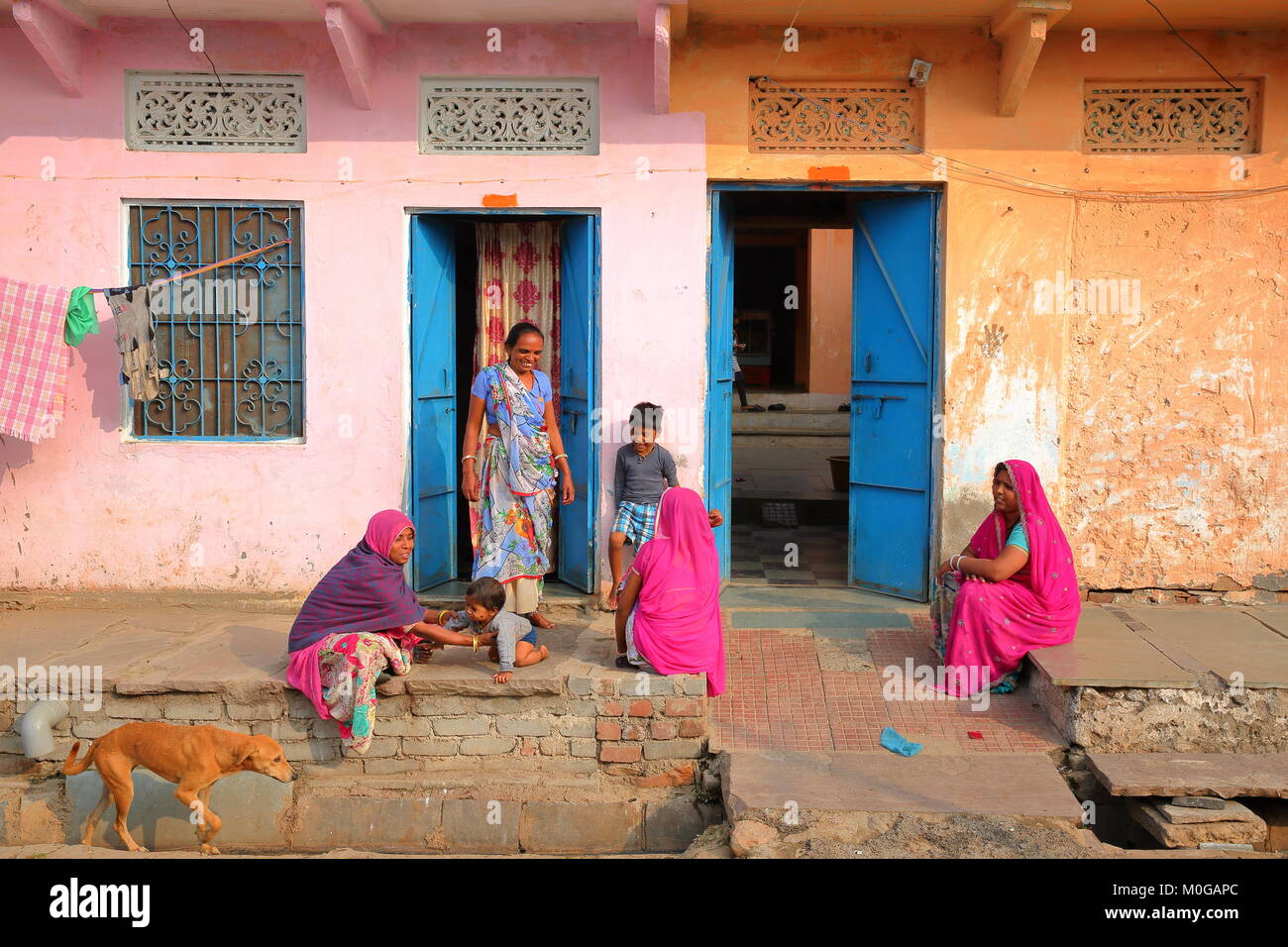 CHITTORGARH, Rajasthan, Indien - Dezember 14, 2017: Street Scene mit Frauen und Kinder, die vor ihren traditionellen und farbenfrohen Haus Stockfoto