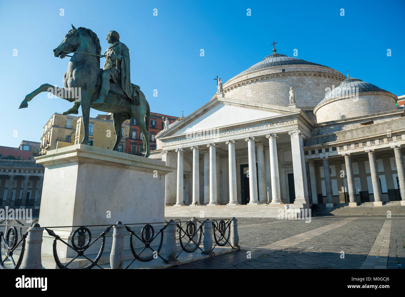 Malerischer Blick auf die Basilika Reale Pontificia San Francesco Di Paola durch eine bronzene Reiterstatue von Ferdinand I. von Bourbon in Neapel Italien dominiert Stockfoto