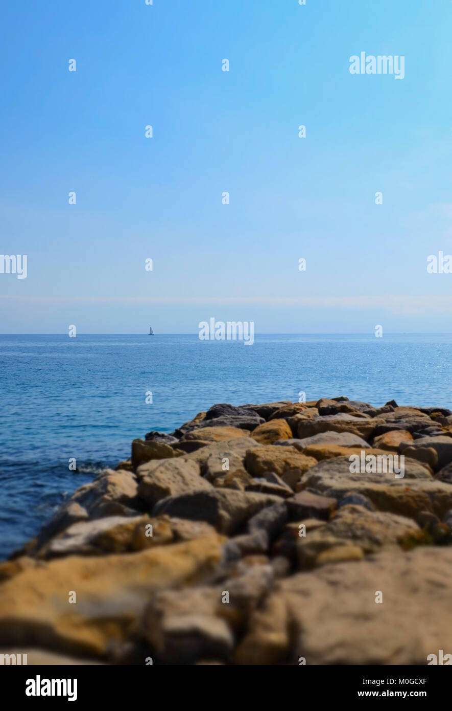 Dock aus Felsen und das offene Meer, geringe Tiefenschärfe. San Remo, Italien. Stockfoto