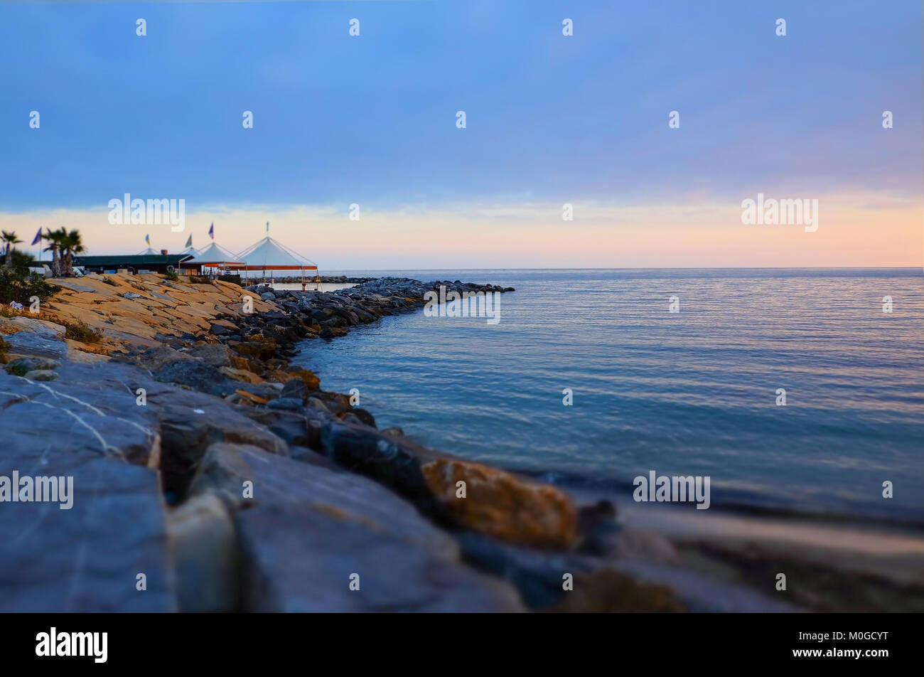 Sonnenuntergang auf einem felsigen Strand, geringe Tiefenschärfe. San Remo, Italien. Stockfoto