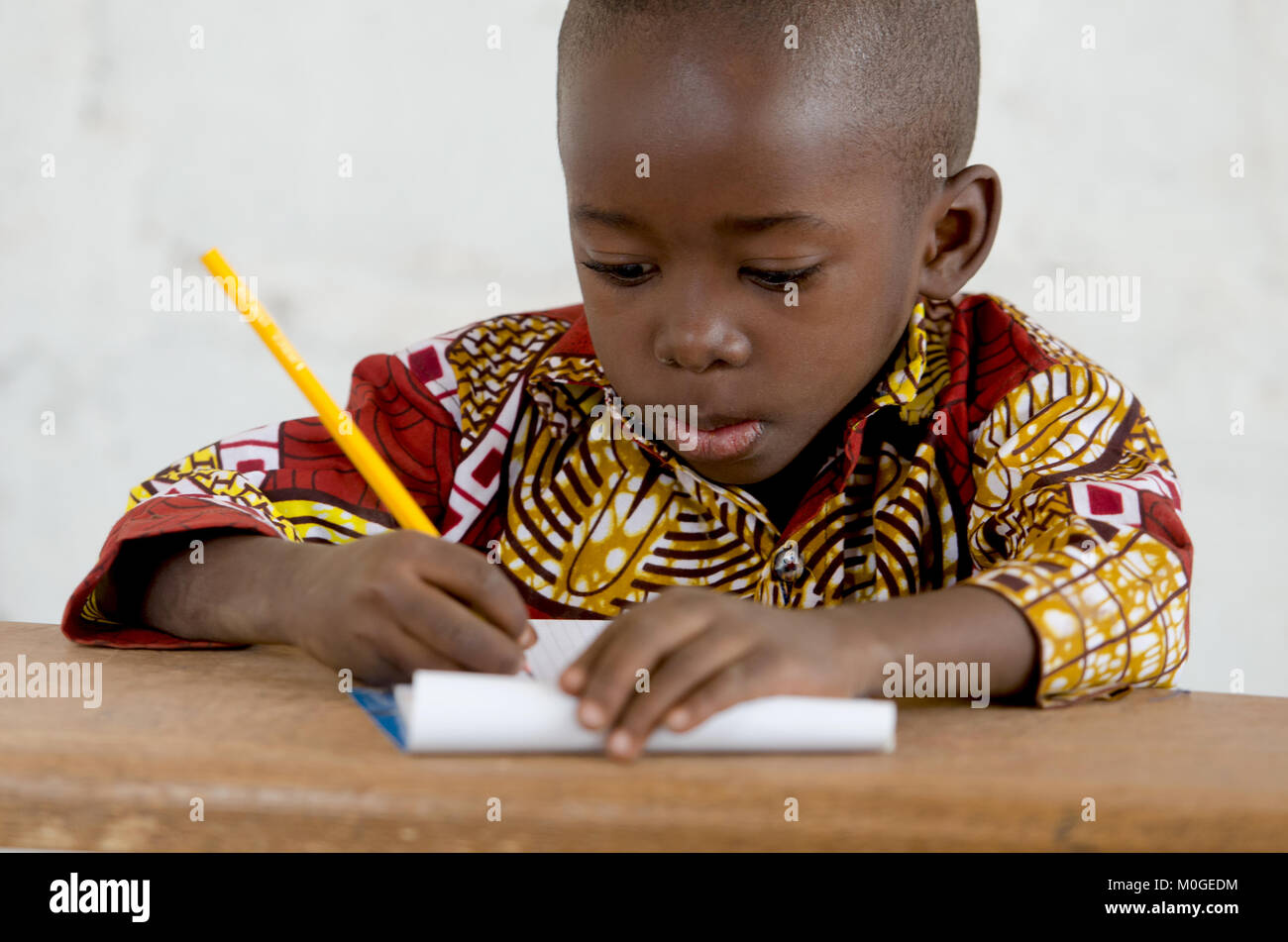 Wenig afrikanischen schwarzen Jungen im Unterricht Schreiben von Notizen Stockfoto