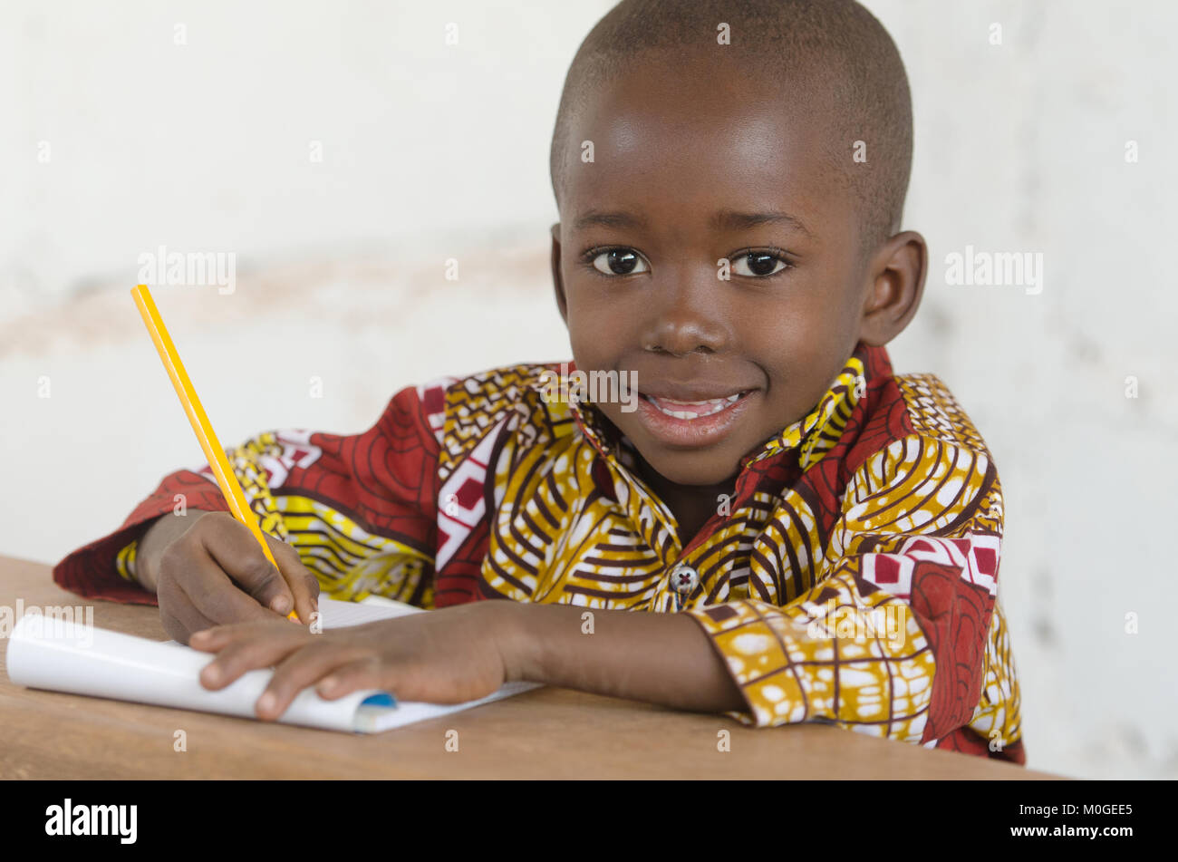 Portrait von Stattlichen kleinen afrikanischen schwarzen Jungen Schreiben lernen Stockfoto