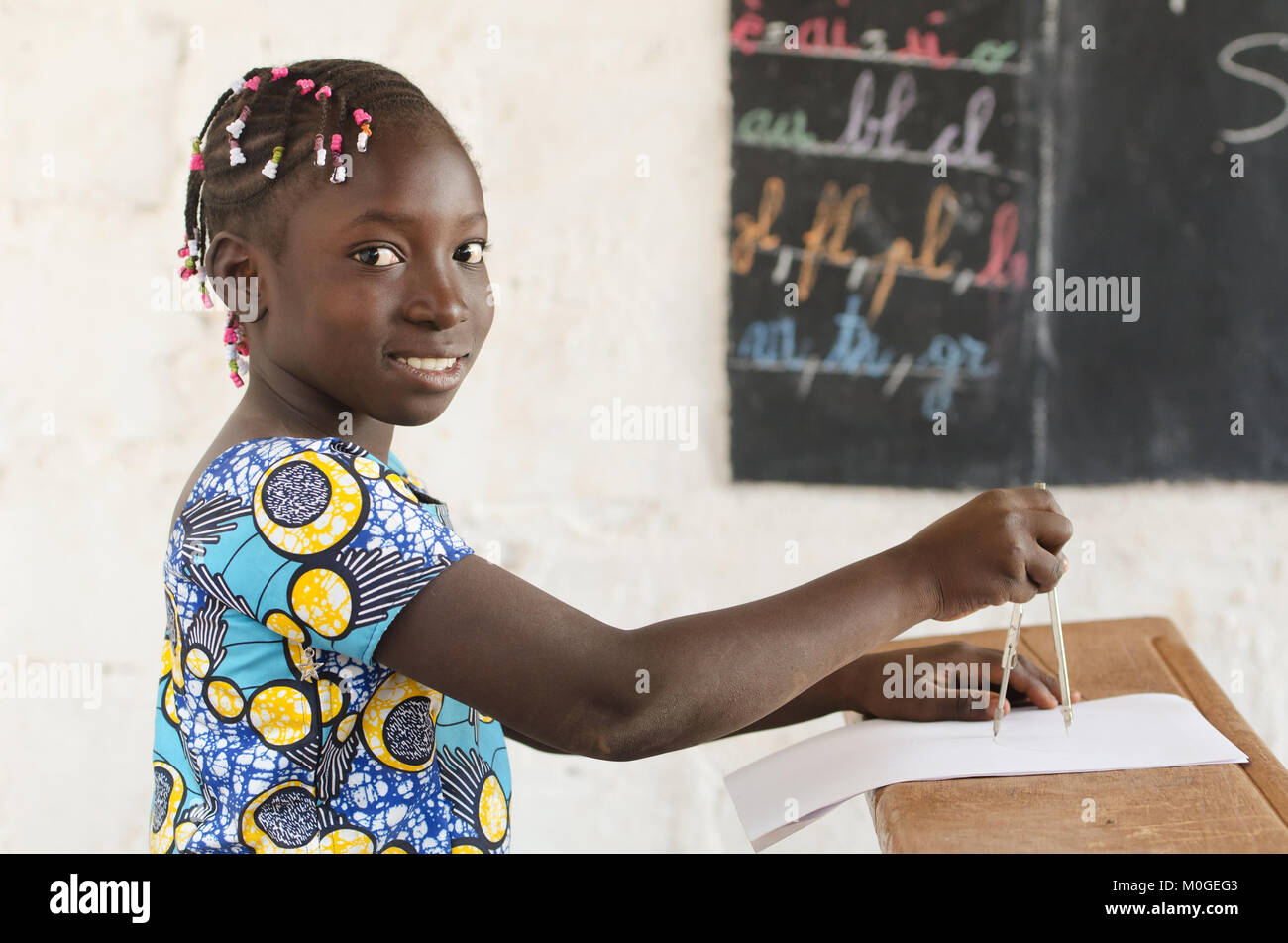 Afrika und Technik - Schöne Afrikanische Mädchen in der Schule mit Kompass und Blackboard Stockfoto