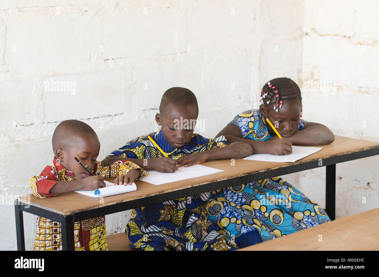 Drei schöne afrikanische Kinder in der Schule sich Notizen während der Klasse Stockfoto