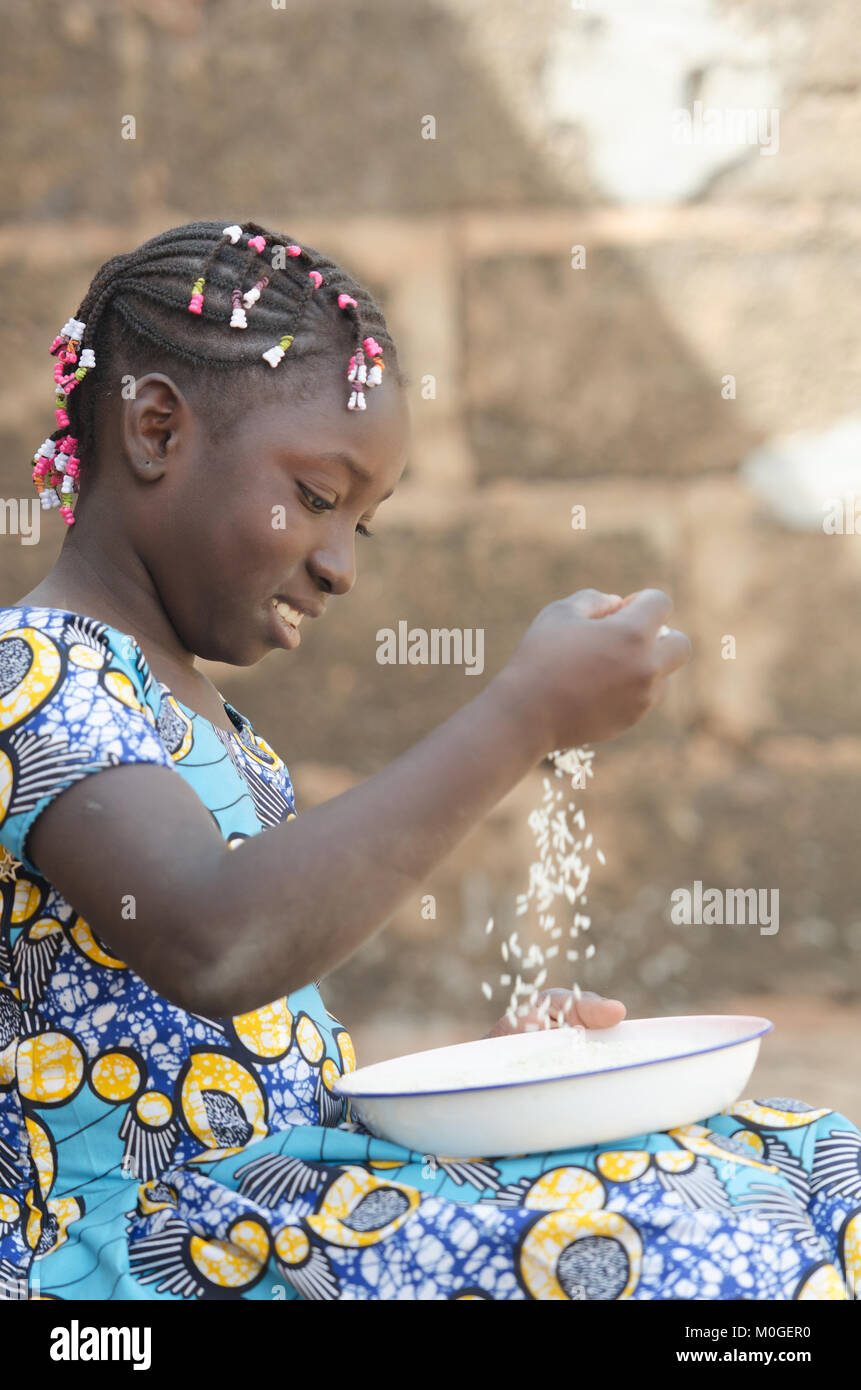 Adorable Porträt eines kleinen afrikanischen Mädchens Vorbereitung Reis für Essen Stockfoto