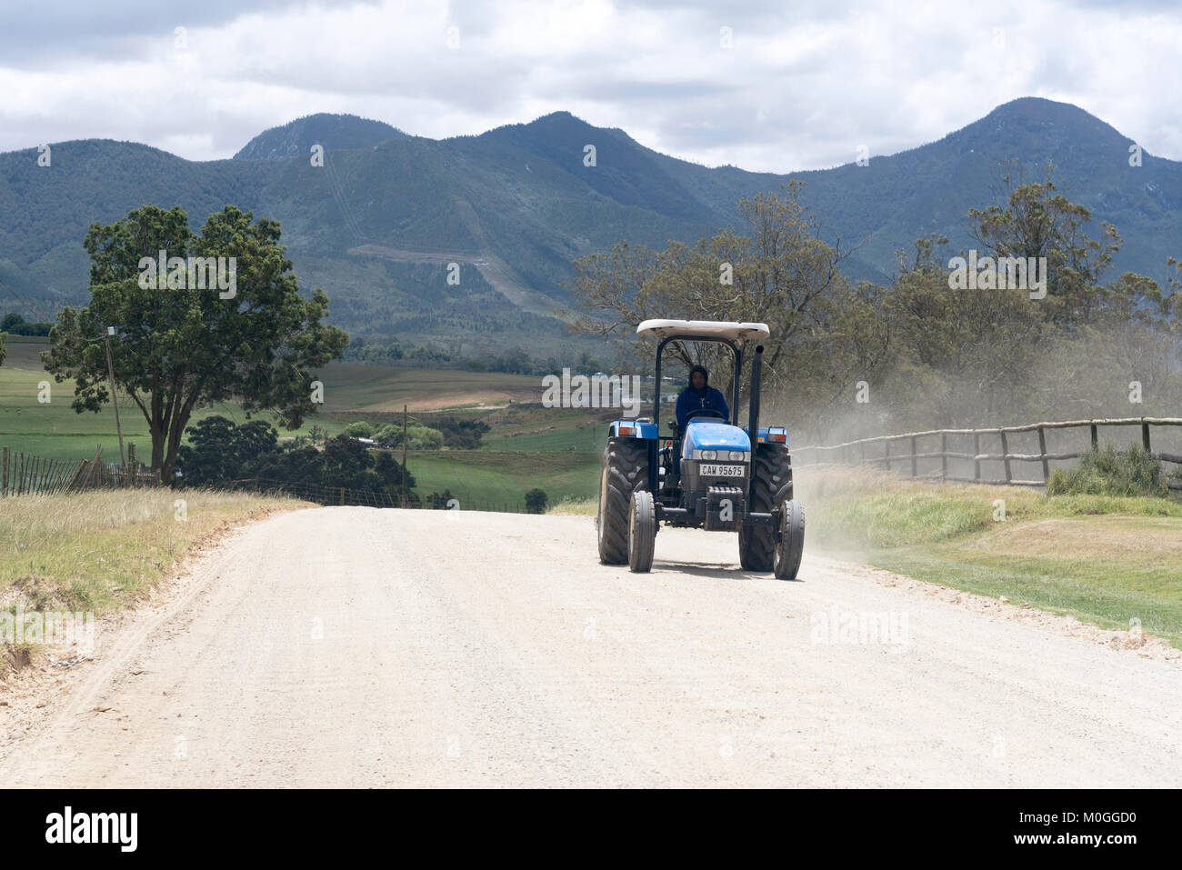 George Western Cape Südafrika. Dezember 2017. Ein Feldweg und blauen Traktor in ländlicher Lage in der Nähe von George mit einer Kulisse der Outeniqua Stockfoto