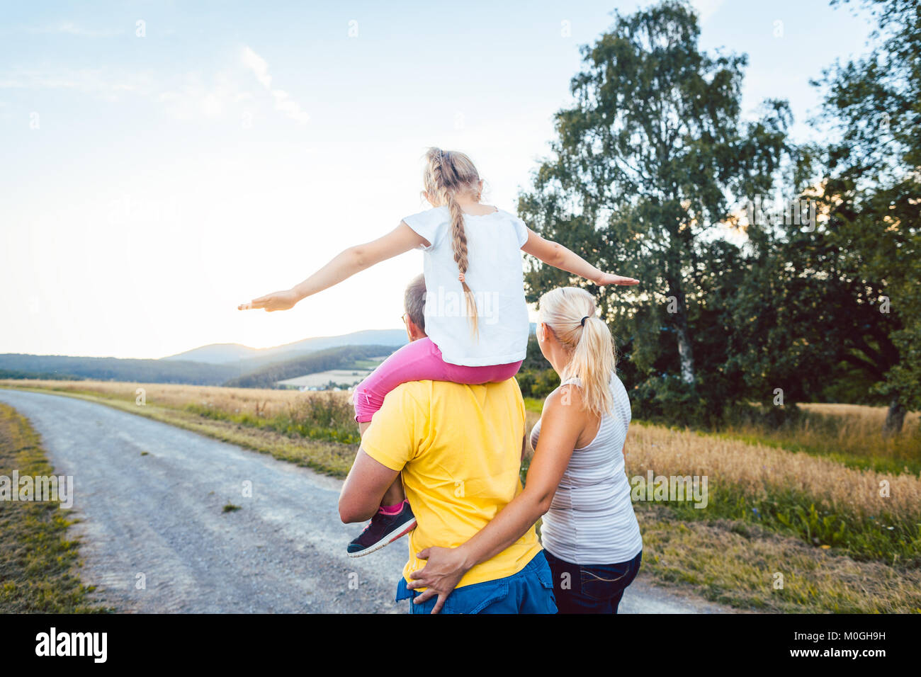 Familie mit Kind Huckepack auf Sommer Spaziergang Stockfoto