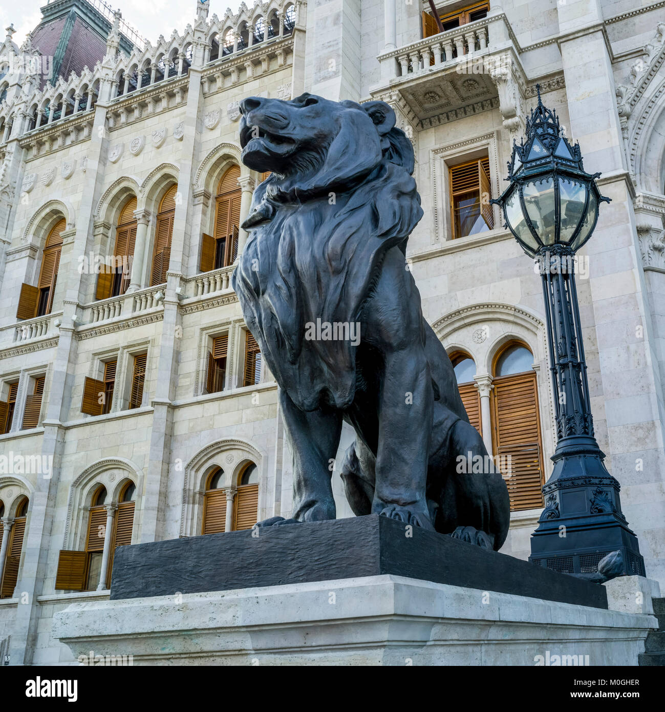 Skulptur eines Löwen und Lamp Post außerhalb der Ungarischen Parlament, Budapest, Ungarn; Budapest, Budapest, Ungarn Stockfoto