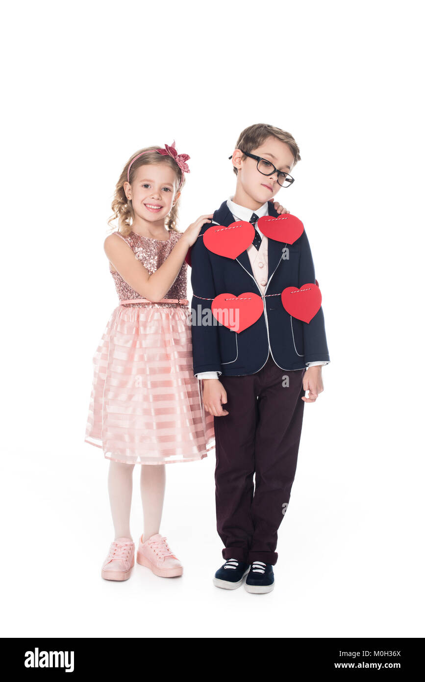 Gerne kleine Mädchen umarmt umgekippt Junge gebunden mit Seil und roten Herzen isoliert auf weißem Stockfoto