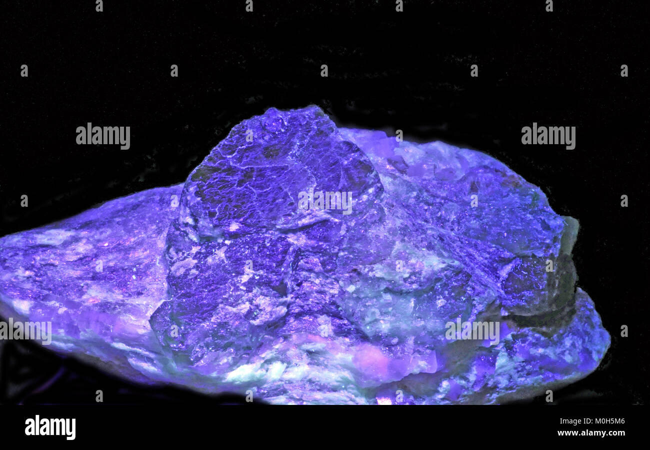Das Foto zeigt eine smaragdgrüne beryl-on-Matrix aus Panjshir, Afghanistan, beleuchtet unter ultraviolettem Licht und enthüllt seine natürliche Kristallstruktur. Stockfoto