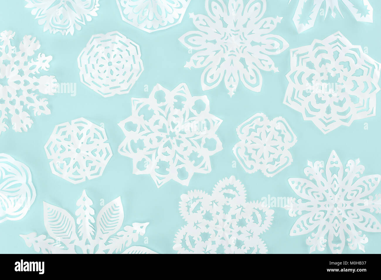 Weihnachten Hintergrund mit dekorativen Papier Schneeflocken, isoliert auf Hellblau Stockfoto