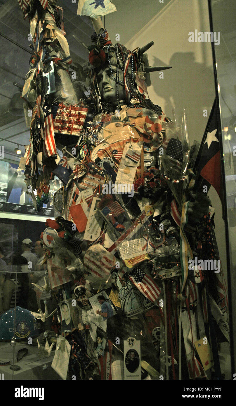 Eine kleine Nachbildung der Freiheitsstatue auf nationaler September 11 Memorial and Museum mit einer Flagge zeigen alle die Namen der Getöteten während 9 / Stockfoto