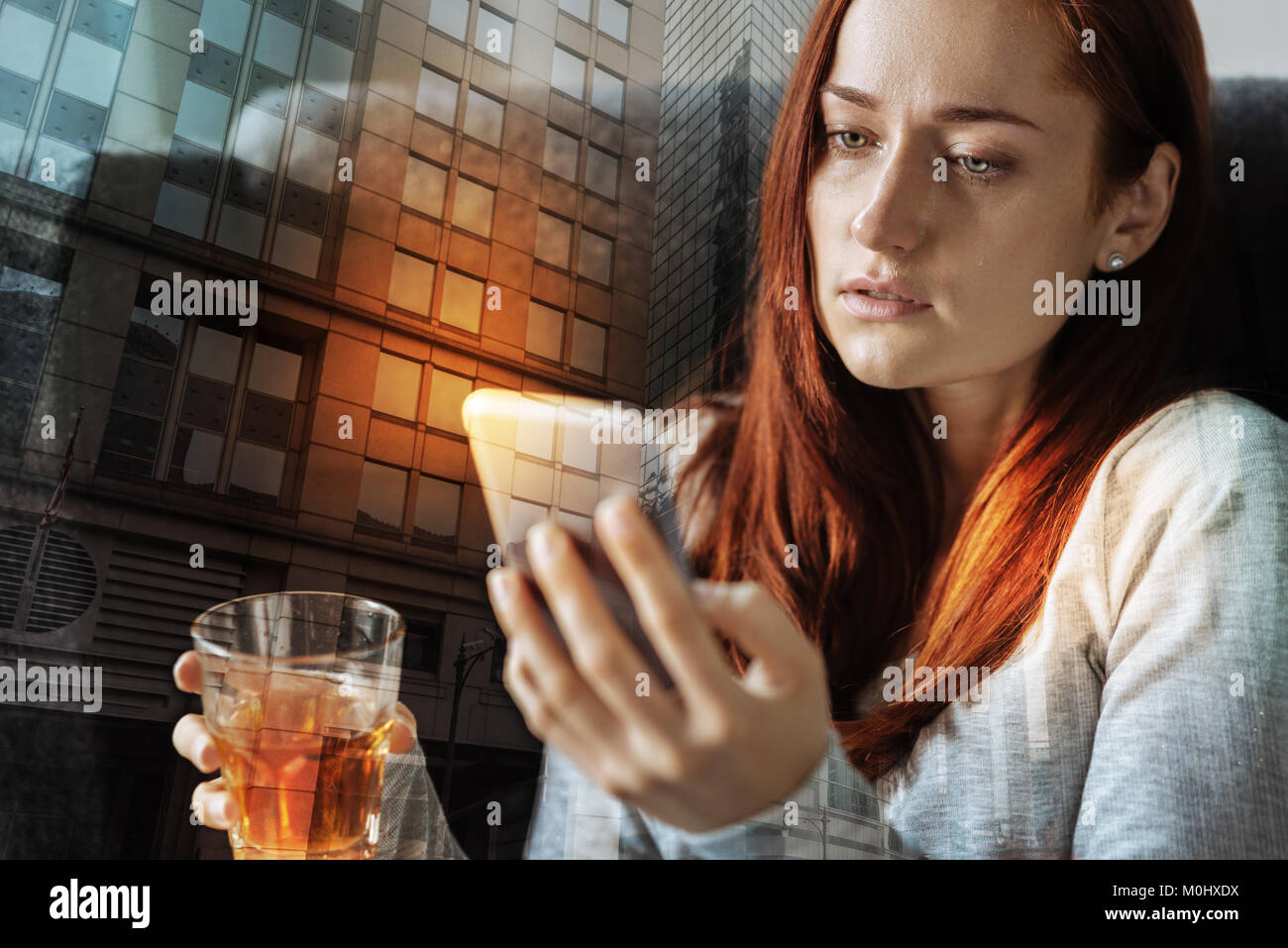 Ernsthafte Frau schlechte Gefühl beim Trinken von Alkohol und an Ihr Smartphone Stockfoto