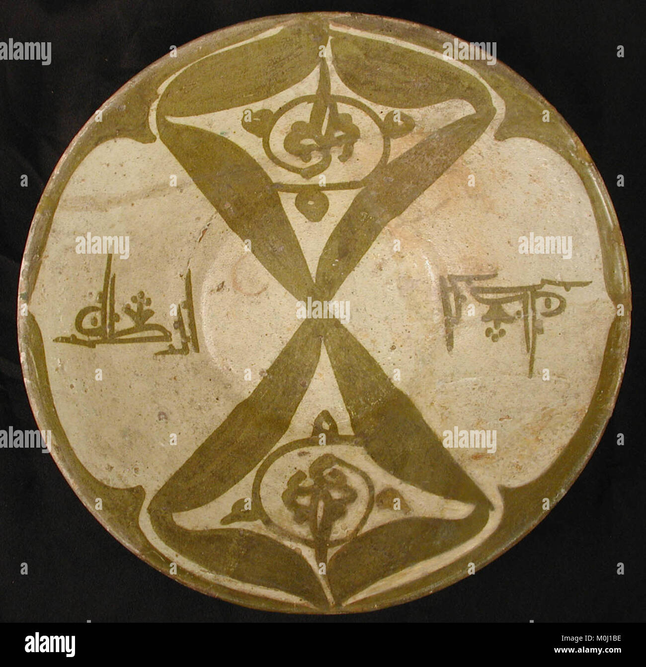 Die Imitation Luster Bowl, Inschrift Segen, ist eine Schüssel aus weißem Ton aus dem 10. Jahrhundert mit einfarbigem Glanz unter einer transparenten Glasur, die zweimal mit dem Wort „Segen“ beschriftet ist – einmal nach oben und einmal nach unten –, um Glück zu beschwören. Es imitiert frühere irakische monochrome Glanzwaren und spiegelt die Keramiktradition von Nishapur und ihren Einfluss wider. Stockfoto