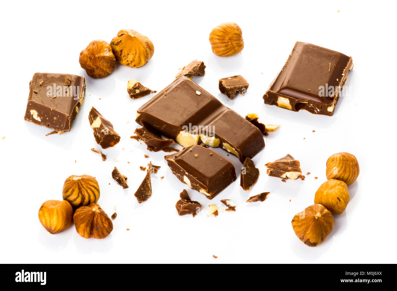Stück Schokolade mit Haselnüssen in mehreren auf weißem Hintergrund Stockfoto