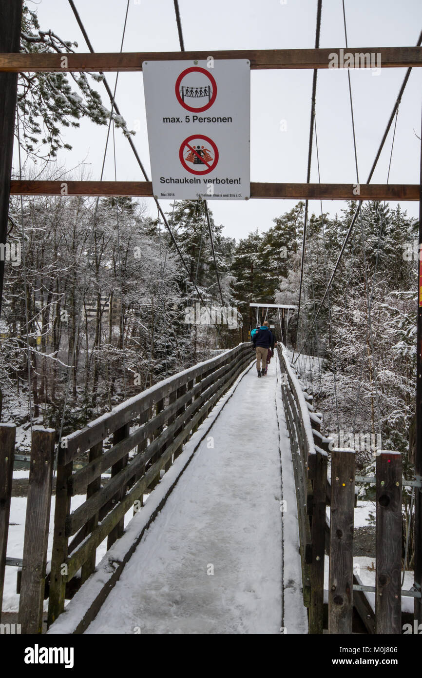 Gruppe von Menschen, die über eine Holzbrücke über einen Fluss in Thusis im Kanton Graubünden (Graubünden), Schweiz Stockfoto