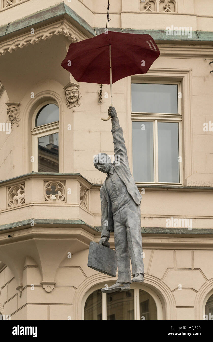 Die Umbrella Man von Prag, eine moderne Kunst Statue eines Mannes hängt von einem Regenschirm, die hoch über einem Prager Straße Stockfoto