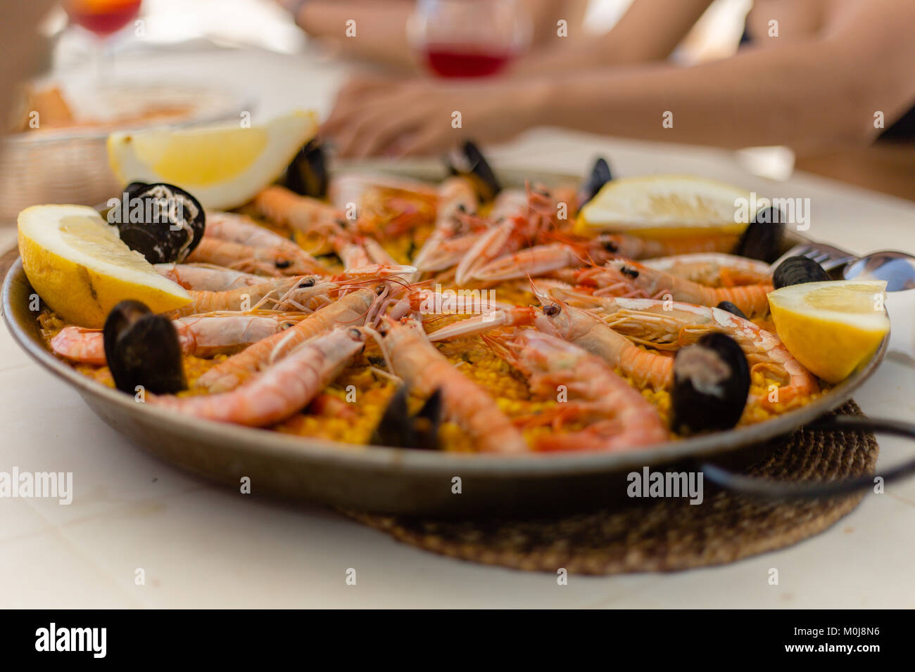 Paella: Eine traditionelle spanisch-mediterrane Fischgerichte Teller, serviert in der traditionellen Pan. Ein ausgezeichnetes Essen mit Freunden und Familie durch das Meer zu teilen. Stockfoto