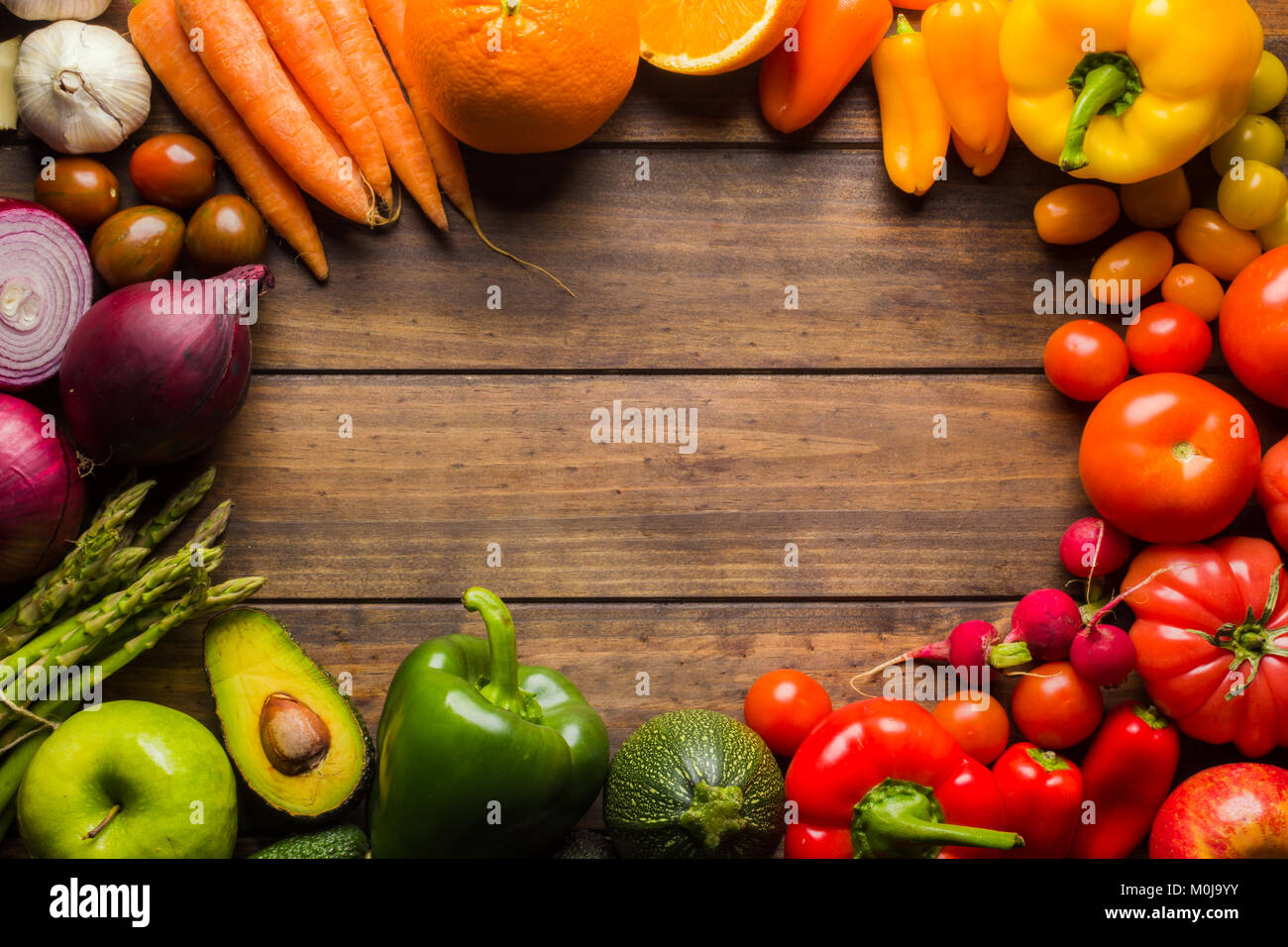 Rahmen der verschiedenen Arten von Obst und Gemüse auf einem Holztisch mit negativen Raum zu Logo oder Text platzieren. Stockfoto