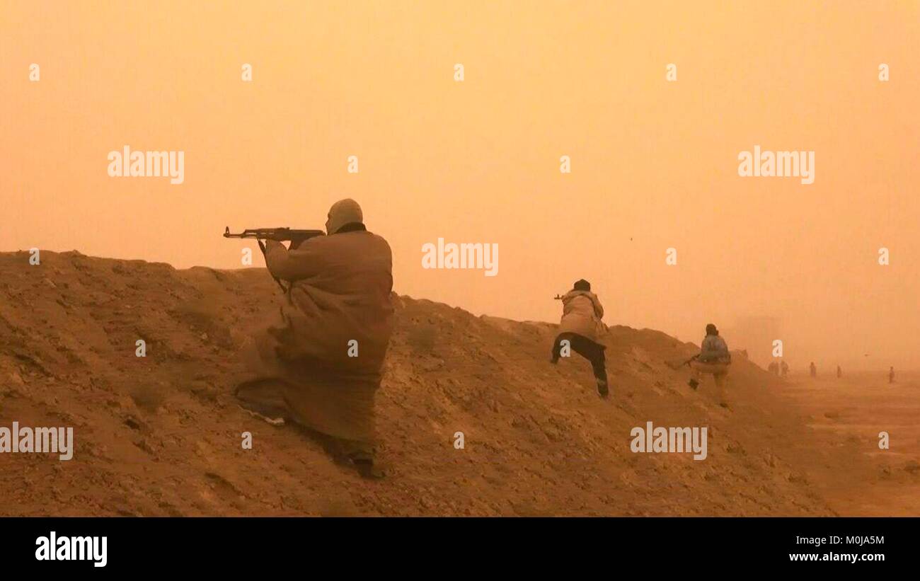 Standbild aus einer Propaganda Video veröffentlicht Januar 19, 2018, islamischen Staat Kämpfer starten einen Angriff gegen die syrische Regierung Kräfte während einem Sandsturm außerhalb Deir ez-Zor, Syrien. Stockfoto