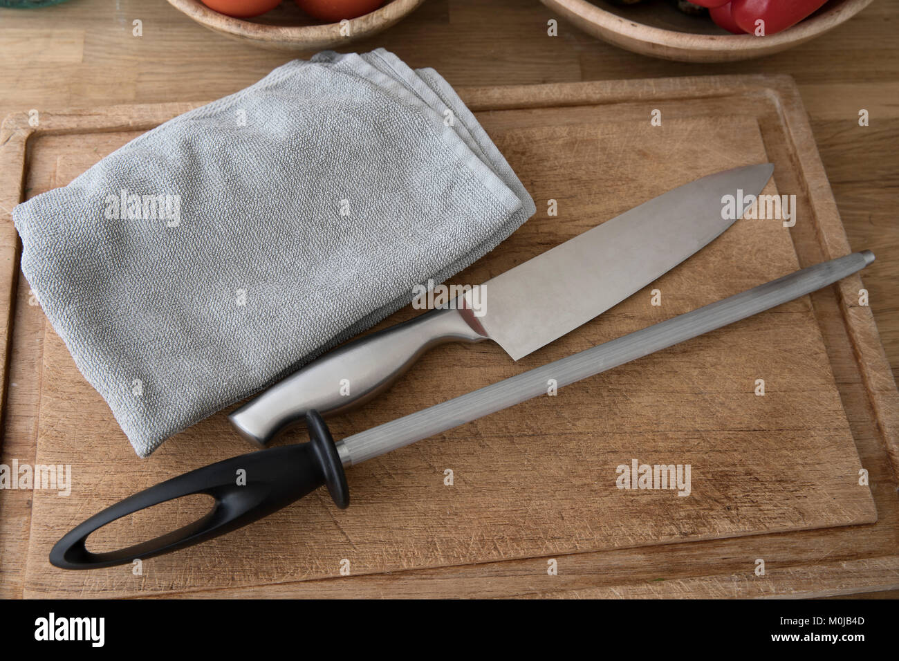 Kochmesser, Honen Stahl- und Handtuch auf ein Schneidbrett, Vorbereitung für die Messer schärfen. Stockfoto