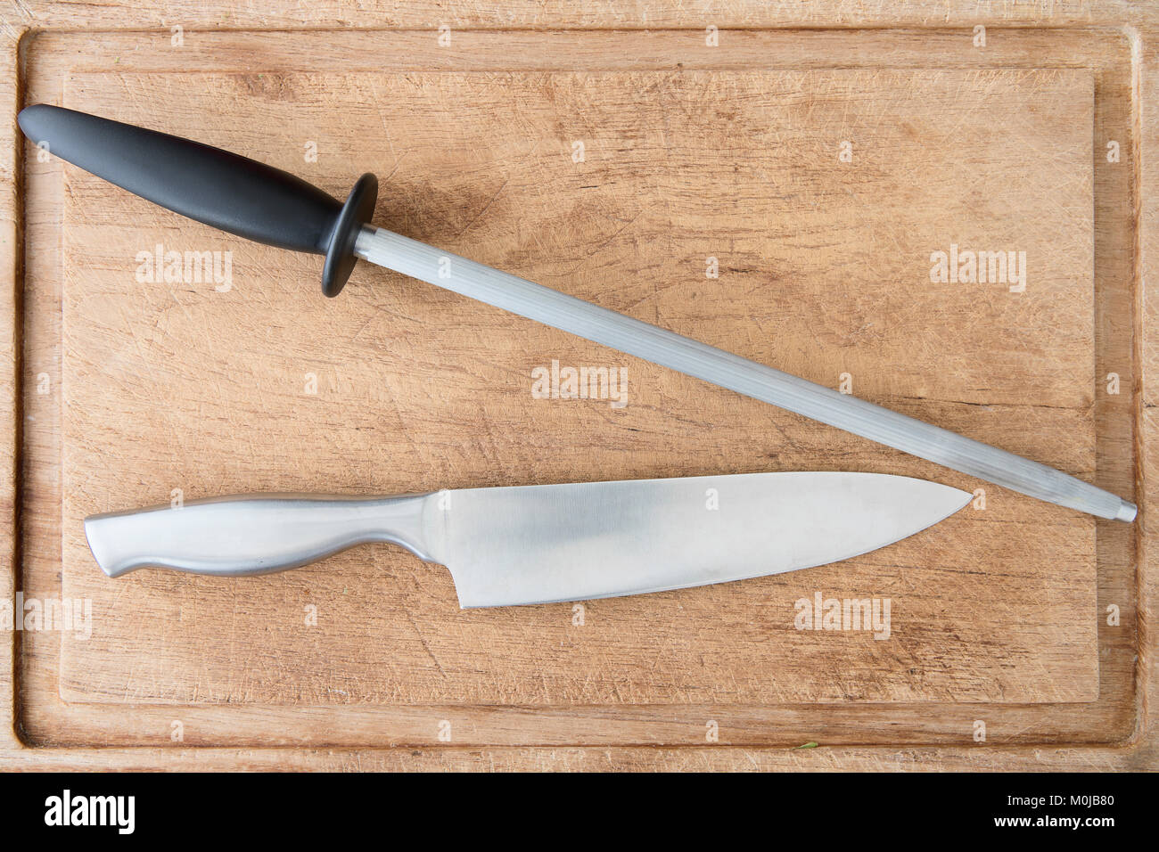 Messer und honen Stahl auf schneidebrett von oben gesehen. Stockfoto