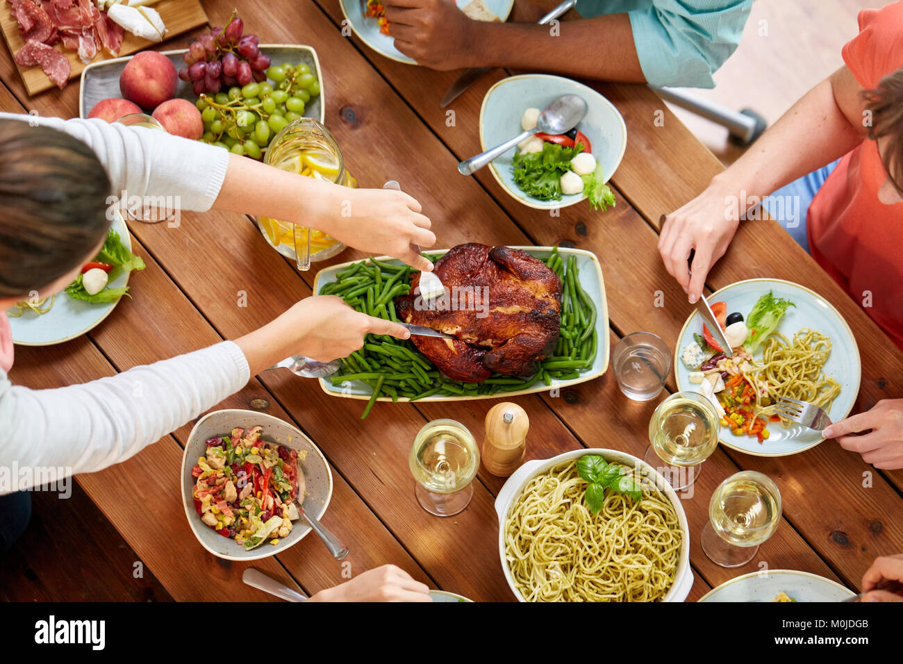 Gruppe von Menschen, die Huhn essen zum Abendessen Stockfoto