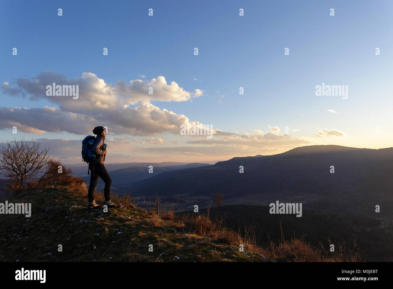 Frau, die oben am Hügel mit Panoramablick bei Sonnenuntergang, Veli Badin, Socerga, Slowenien. Stockfoto
