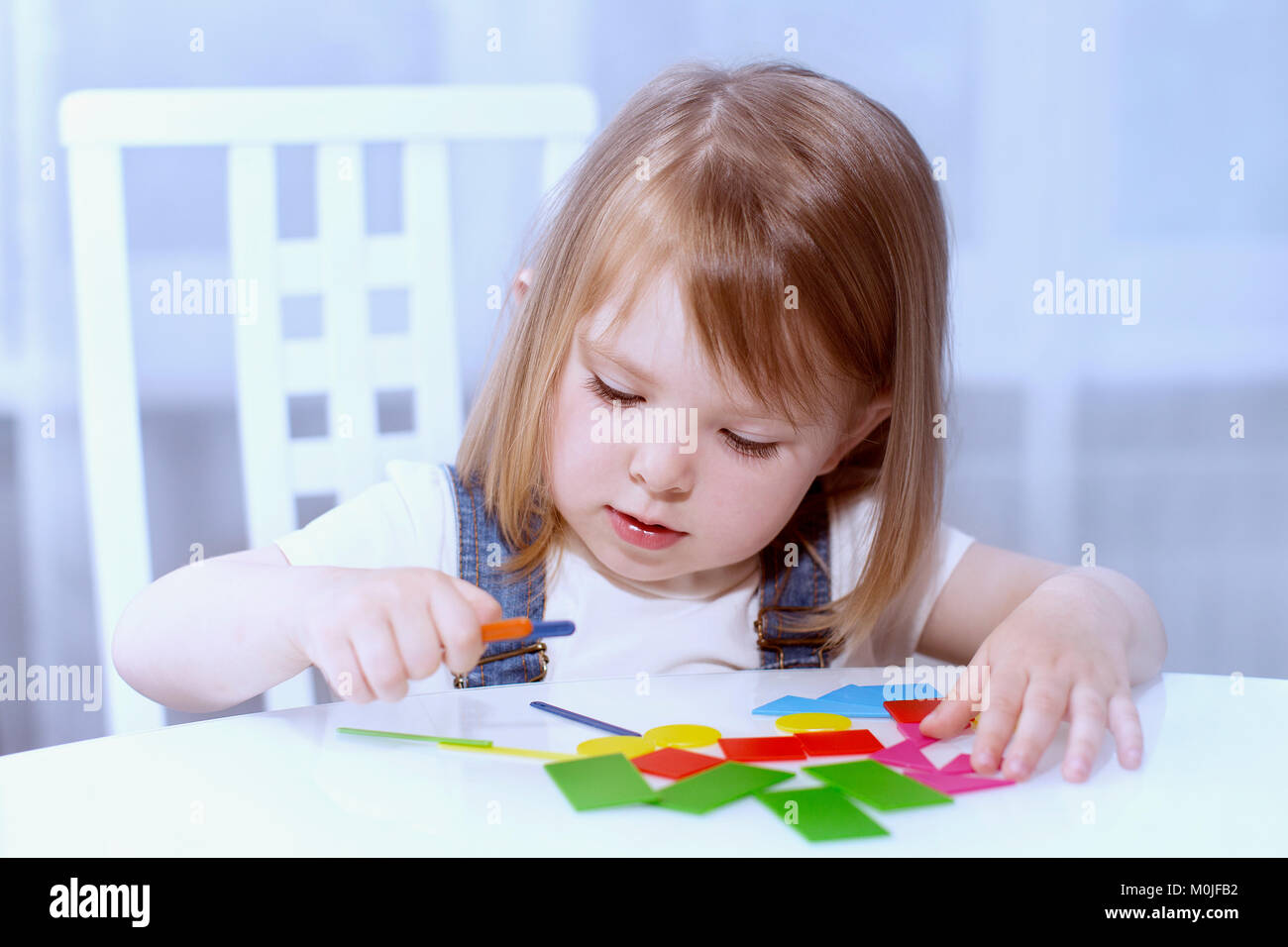 Ein kleines Mädchen erinnert sich geometrische Formen. Horizontale Stockfoto