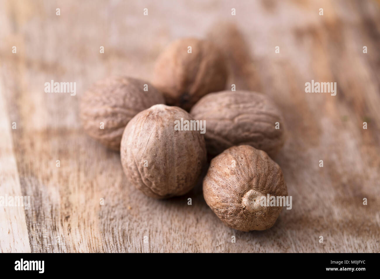 Ganze Muskatnuss auf Holzmöbeln im Landhausstil Oberfläche Stockfoto