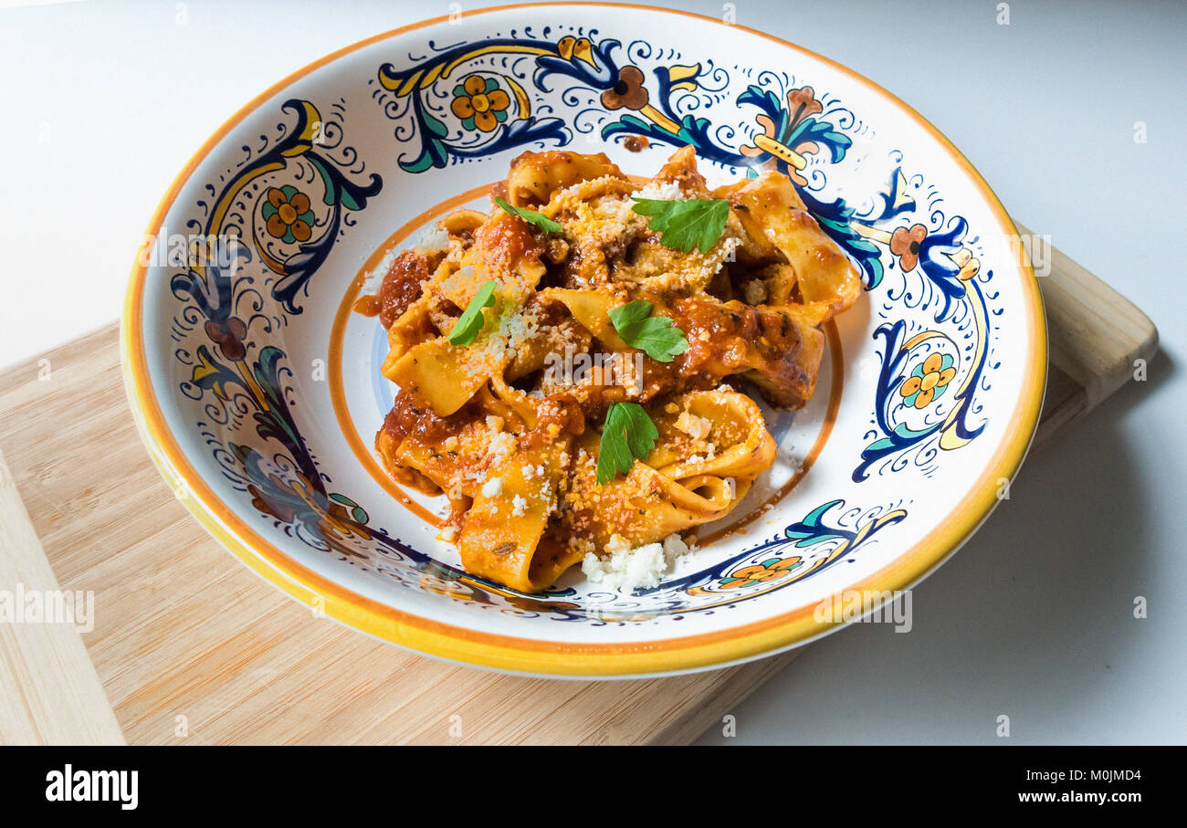 Eine kleine Portion Pappardelle Bolognese in einer verzierten italienischen Schüssel Stockfoto