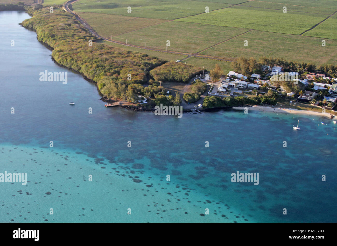 Lagune, Feldern und kleinen Bauerndorf aus einem Hubschrauber, Savanne Bezirk der Republik Mauritius gesehen. Stockfoto