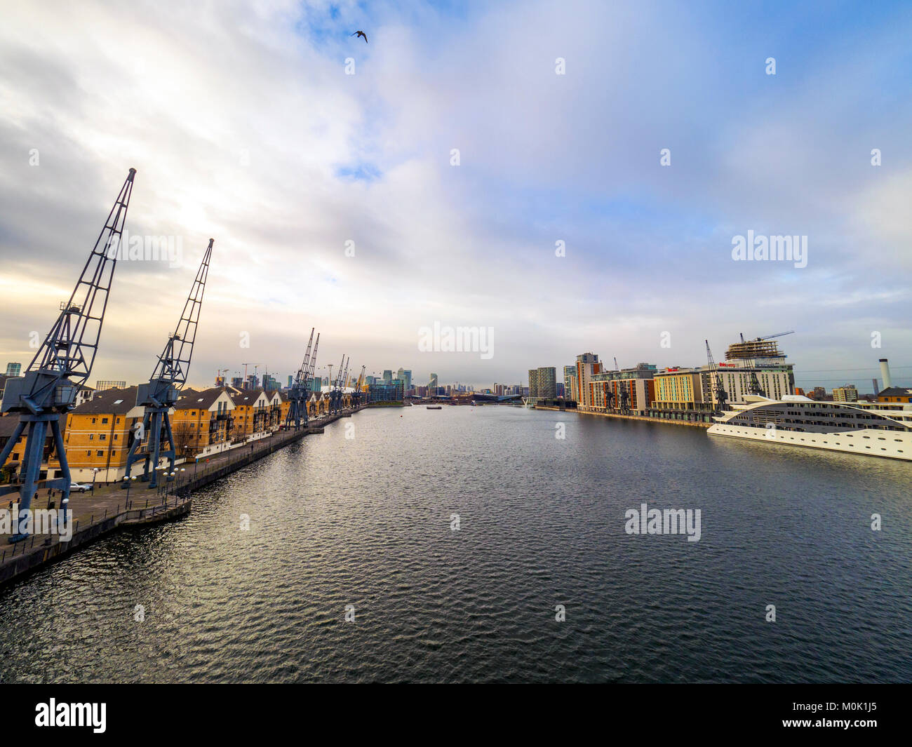 Moderne mews Häuser und alte Krane mit Blick auf das Royal Victoria Dock in East London - England Stockfoto