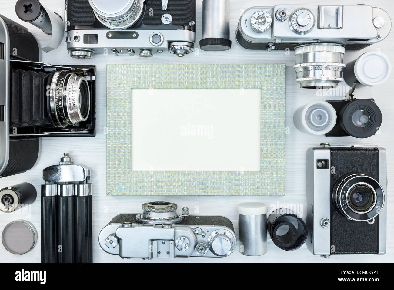 Alte klassische Foto Kameras, leeren Bilderrahmen, negative Filmrollen und Stativ auf weißem Hintergrund Holz Draufsicht Stockfoto