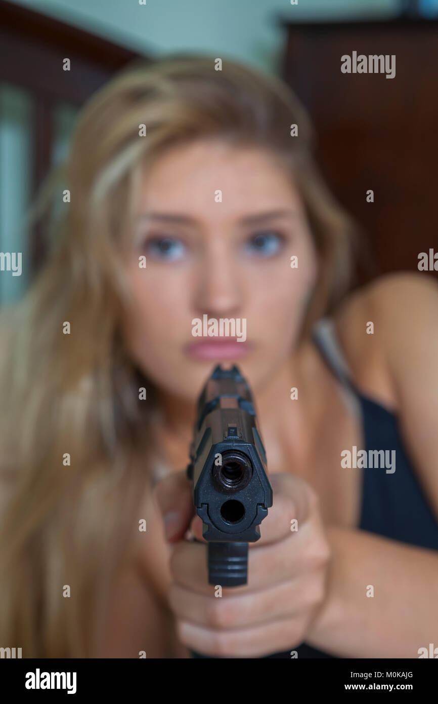 Junges Mädchen mit blonden Haaren, die auf eine Waffe auf die Kamera; Connecticut, Vereinigte Staaten von Amerika Stockfoto