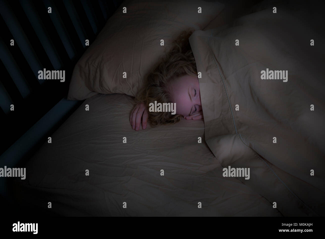 Junges Mädchen mit blonden Haar in ihrem Bett lag; Connecticut, Vereinigte Staaten von Amerika Stockfoto