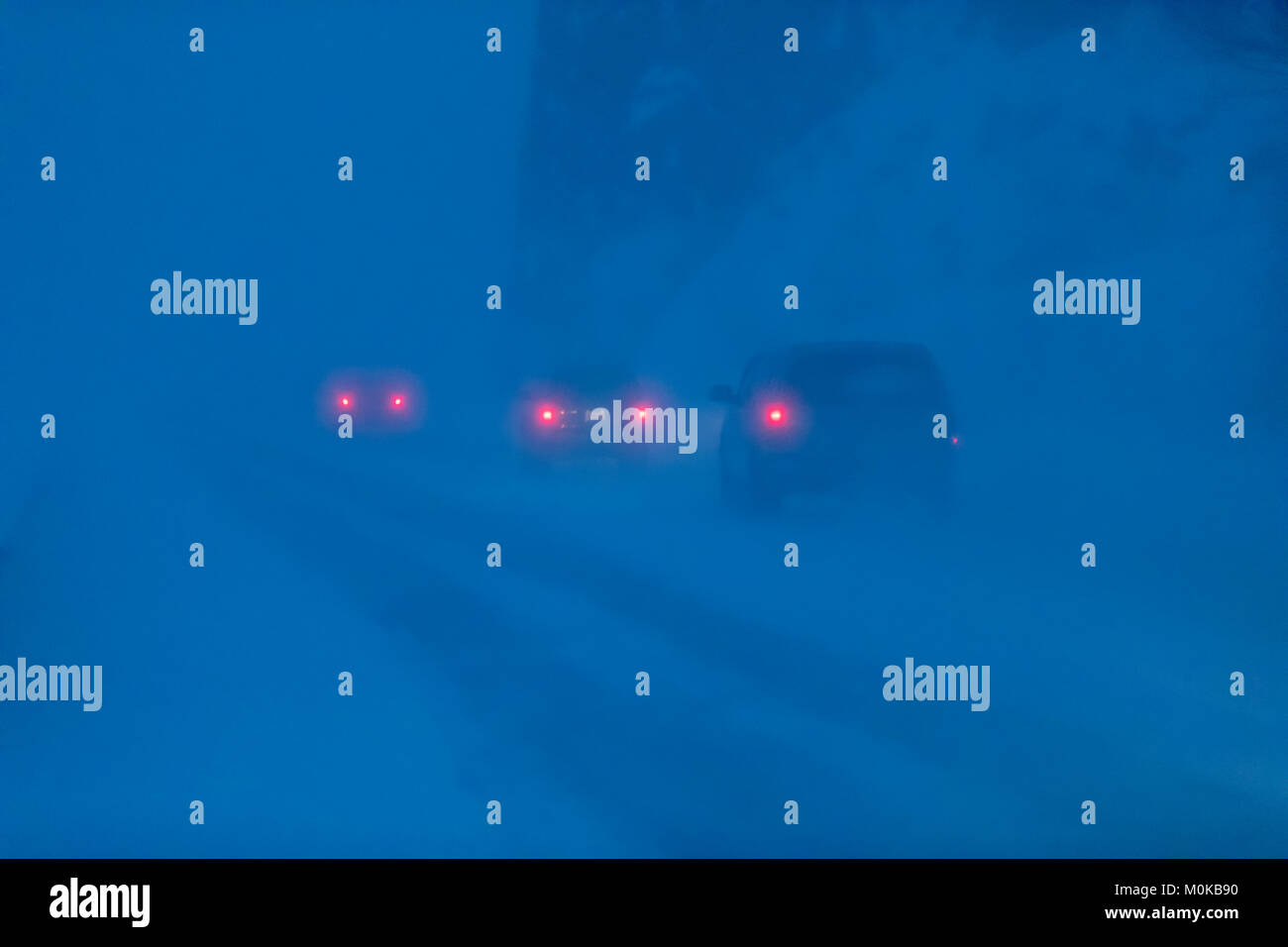 Auto Rückleuchten im Schneegestöber auf dem Seward Highway leuchtet auf, während eine dunkle, Winternacht, Turnagain Arm, Kenai Halbinsel südlich-zentralen Alaska Stockfoto