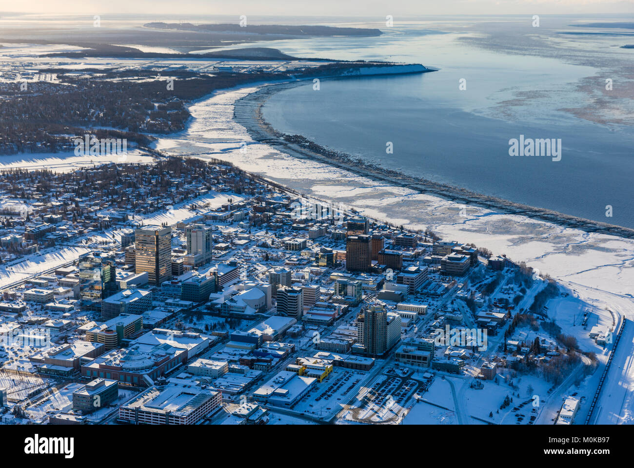 Luftaufnahme von Schnee in der Innenstadt von Anchorage und Cook Inlet bei Ebbe, die Gebäude des Hotel Captain Hook und Conoco Philips im Vordergrund, ... Stockfoto