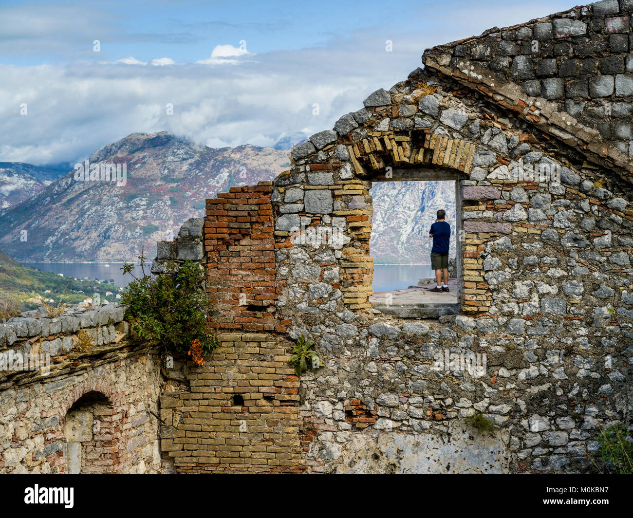 Eine männliche Touristen stehen bei der Kotor Schloss von San Giovanni mit Blick zum Wasser, Kotor, Montenegro Stockfoto