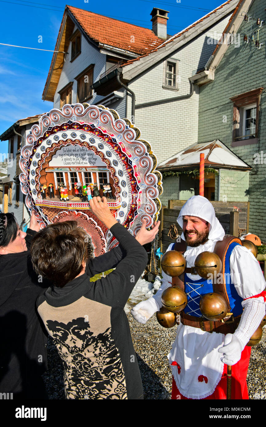 Assistenten helfen eine schöne Chlaus setzen auf die phantastischen Kopfbedeckungen, Silvesterkläuse am Alten Sylvester, Urnäsch, Appenzell Ausserrhoden, Schweiz Stockfoto