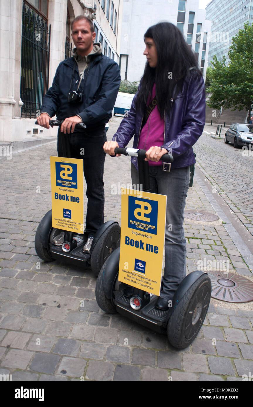 Ein Paar mit einem mieten Segway über die Straße in Brüssel, begium. Stockfoto