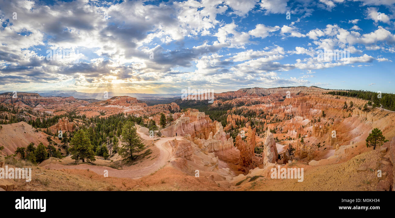 Panoramische Ansicht des Bryce Canyon National Park im schönen goldenen lichter Morgen bei Sonnenaufgang mit dramatischen Wolken und blauer Himmel, Utah, USA Stockfoto