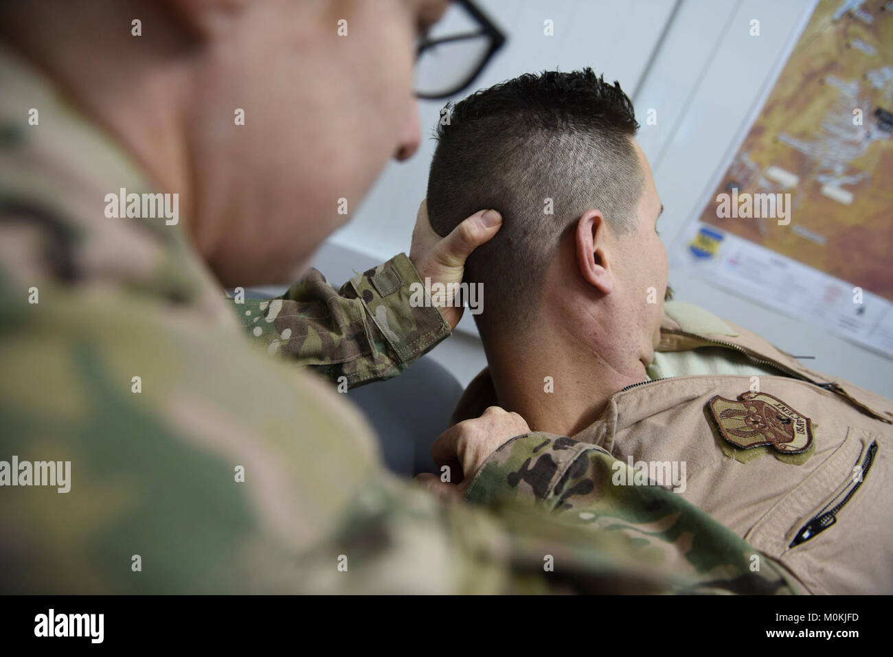 Oberstleutnant Tisha Sutton, 332 d Expeditionary Medical Group Physiotherapeuten, führt ein Pilot aus den 332 d Expeditionary Jagdgeschwader durch eine Reihe von Übungen Flexibilität am 3. Januar 2018 in Südwestasien. Flying 6-8-stündigen Kampf Einsätze bei Nacht erfordert Piloten Helm zu tragen-Night Vision Systeme, welche Orte erhöhte Belastung auf den Hals. (U.S. Air Force Stockfoto
