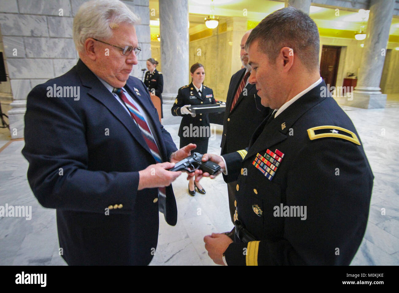 Armee finden Brig. Gen. Doug Cherry (rechts), Stellvertretender kommandierender General, 76th Division (Operational Response), erhält eine M 9 9-mm-Pistole von Oberst (im Ruhestand) Steve Garnison während seiner Promotion Zeremonie allgemeine Jan. 6 an der Utah State Capital Building in Salt Lake City zum brigadier. Cherry trat der Armee im Jahre 1983 und hat in einer Reihe von Führungspositionen während seiner langen Karriere serviert. (Offizielle US-Armee finden Stockfoto