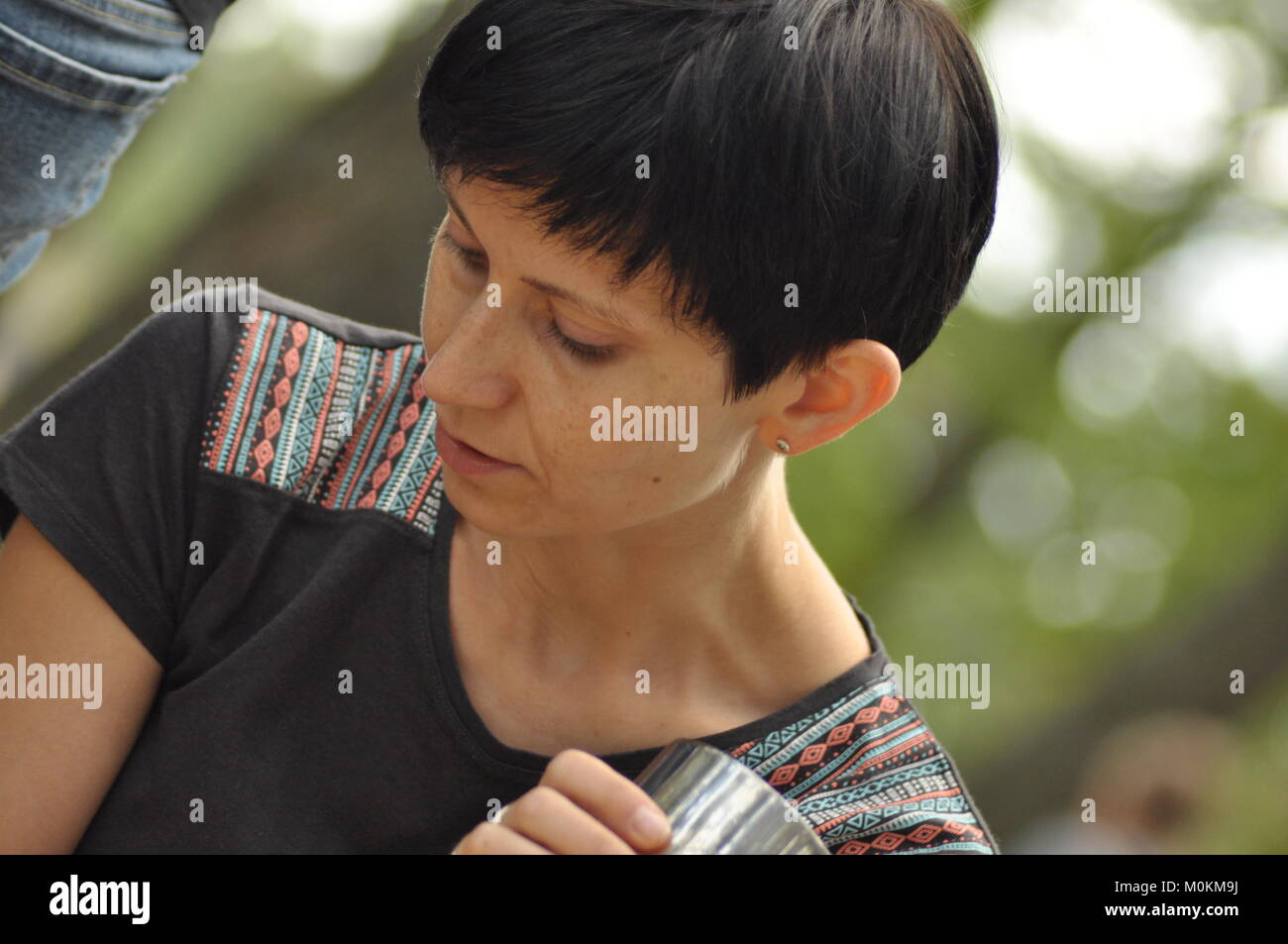 Die Frau unterhalten und nachdenklich. Mädchen mit Ohrringe. Lächeln und Zufriedenheit. Stockfoto