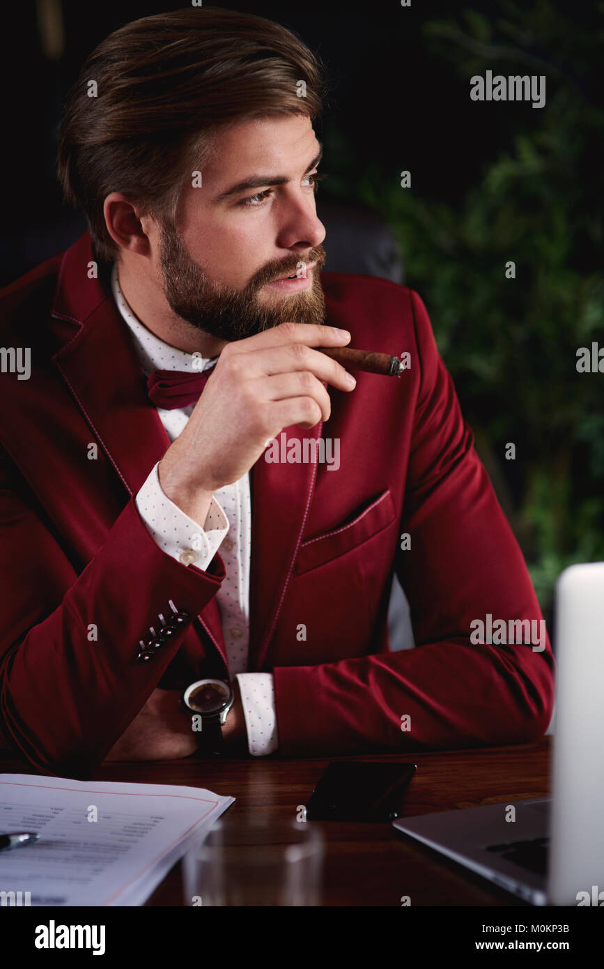 Business Person das Rauchen einer kubanischen Zigarre im Büro Stockfoto