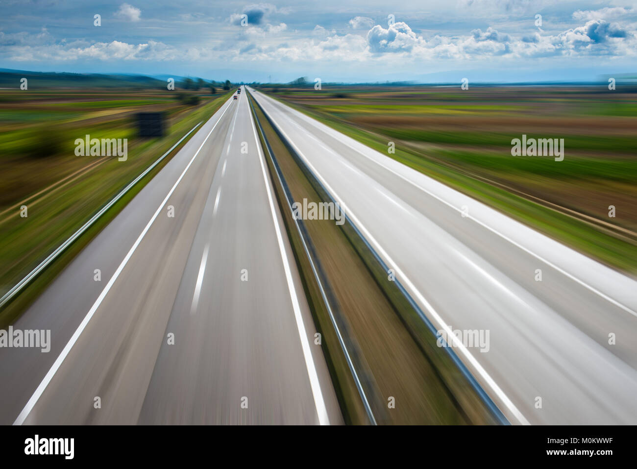 Zoom Effekt auf leere moderne Autobahn durch Felder Stockfoto