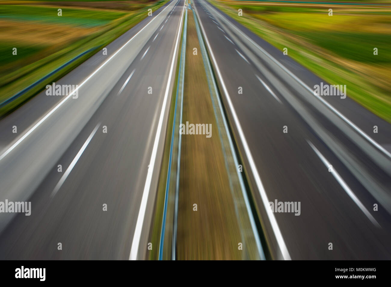 Zoom Effekt auf leere moderne Autobahn durch Felder Stockfoto